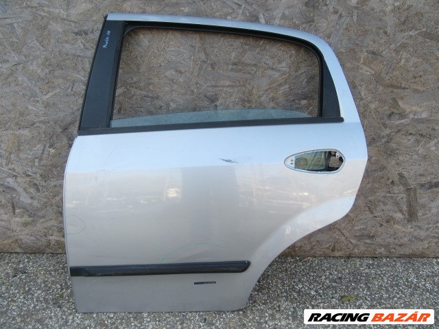 138874 Fiat Grande Punto ezüst színű bal hátsó ajtó, a képen látható sérüléssel 1. kép